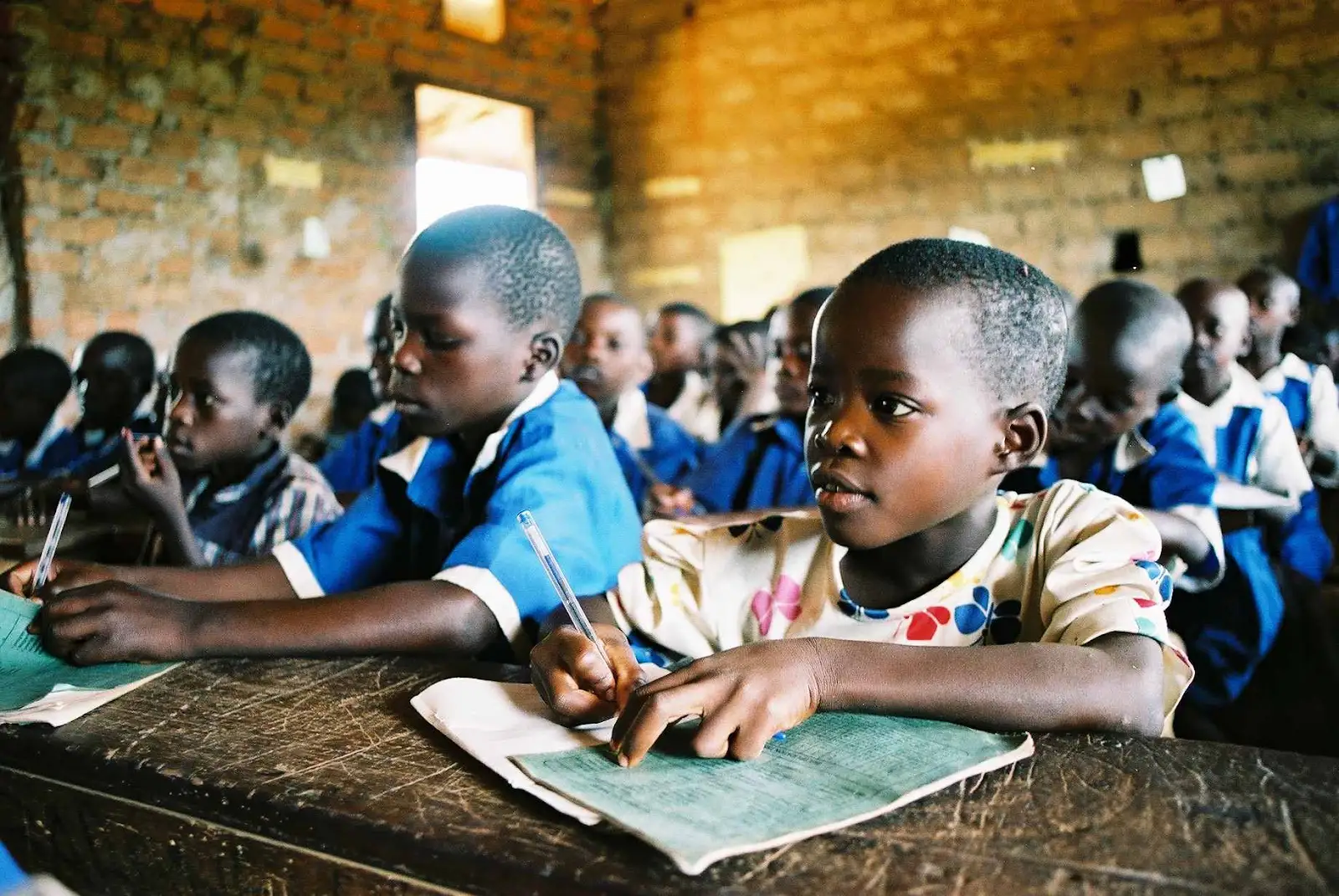 Children writing in their exercise books in a classroom